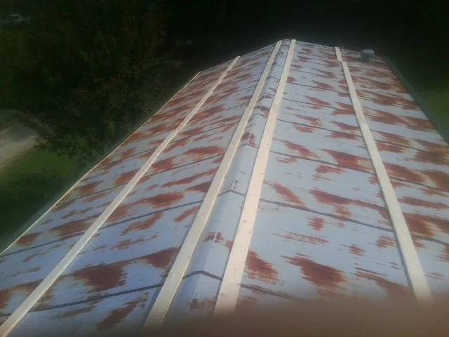 Rusted metal roof panels with new wood purlins before replacement — Storm Damage Roof Repair in Dellrose by Roofing Brothers