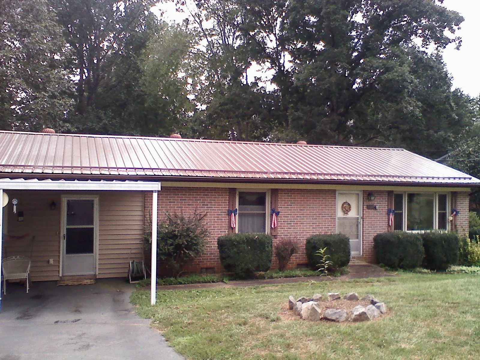 Bronze metal roof and carport on a brick ranch home — Roof Repair work by our crew in Dellrose